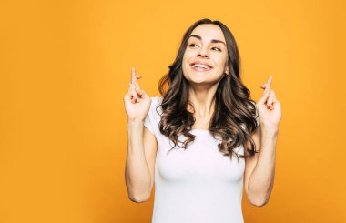 Uygun rüyalar. Kalın koyu kahverengi kıvırcık ve uzun saç, göz alıcı gülümseme ile güzel bir şey kız yüzünden heyecanlı, parmak çarpı işareti ve doğal cilt parlak.