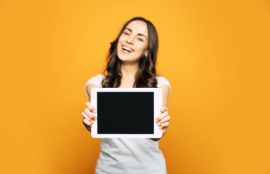 Hoş bir görünüm ve serin Casual kıyafeti ile güzel ve mutlu bir kadının eline yerleştirilen beyaz Tablet PC bir ekran.
