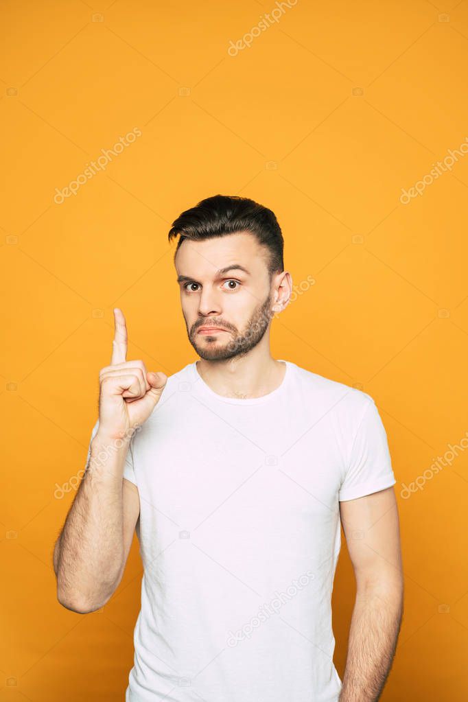 Brain! Man who is thinking about something genius and shows this with his mimics and gestures eight near the hot-orange background