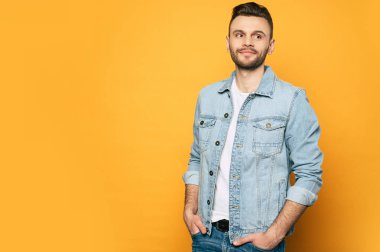 Denim gömlek yakışıklı trendy ve şık sakal adam sarı arka plan üzerinde poz