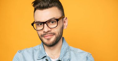 Sarı arka planda izole gözlük yakışıklı sakal adam yakın portresi