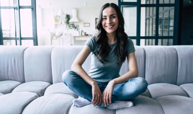 Evde kanepede oturan kapalı gözleri ile gülümseyen mutlu sevimli kadın Portresi