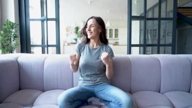 Kanepede otururken dans mutlu genç kadın