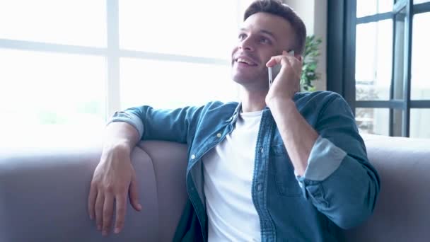 Handsome Young Man Talking Smartphone While Sitting Sofa — Stock Video