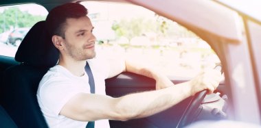 Arabada oturan yakışıklı gülümseyen erkek sürücü