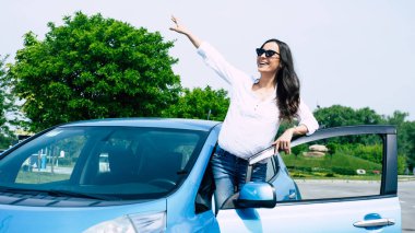 Güzel gülümseyen kadın arabanın yanında poz