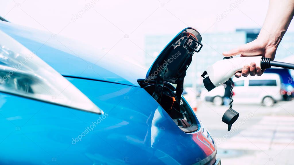 Cropped View of Man Holding Fuel Pump. Refueling Automobile at Gas Station