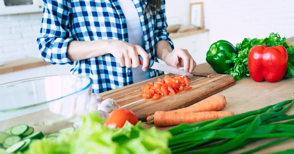 Female hands cutting vegetables in the kitchen. Woman cooking healthy food. Fresh vegetables on the cutting board. Concept of cooking. Diet. Healthy and vegan lifestyle. Cooking at home. Prepare food