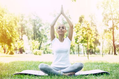 Parkta kadın Yogası. Lotus genç esmer kadın parkta yeşil çim oturan poz. Sakin ve meditasyon konsepti.