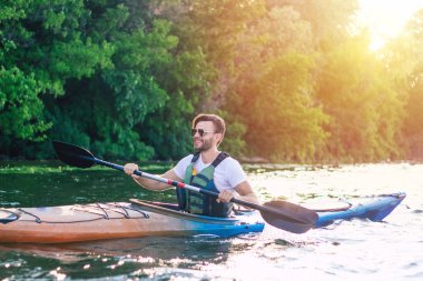 Aktif tatillerin keyfini çıkarın. Kano da kürek çeken aktif adamın arka görünümü