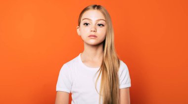 Üzgün gözleri ile küçük sevimli üzgün kız sarı arka plan üzerinde uzağa bakar