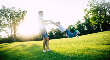 Yakışıklı genç modern baba şehir parkında onun küçük güzel oğlu ile açık havada bir eğlence ve tatil günü var