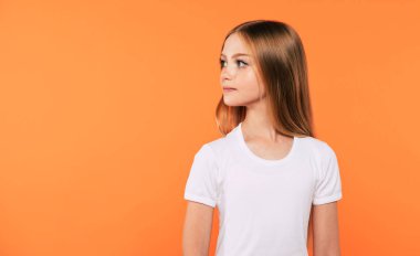 Beyaz t-shirt güzel küçük sarışın kız yan görünüm portre sarı arka planda izole poz