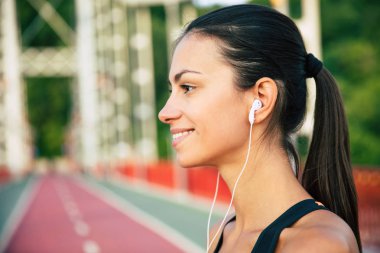 Sabah egzersizleri açık havada spor ve kulaklıklar güzel sportif ince esmer kadın