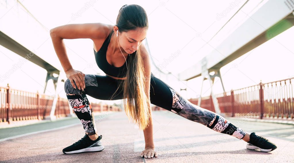 Female sporty and healthy lifestyle. Attractive young brunette girl is doing morning exercises before run