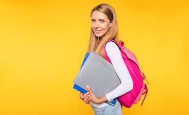 Çalışma, eğitim, üniversite, üniversite, sarı arka plan üzerinde lisansüstü kavramı. Güzel gülümseyen sarışın kadının portresi. Sırt çantası ile genç öğrenci