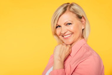 Stüdyoda izole mutlu gülümseyen ve güzel sarışın yaşlı kadın yakın portre ve kamera gülümseme ile poz