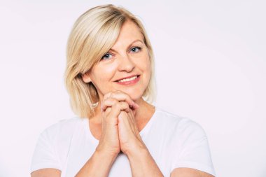 Stüdyoda izole mutlu gülümseyen ve güzel sarışın yaşlı kadın yakın portre ve kamera gülümseme ile poz