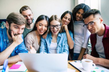 Ofiste veya co-çalışma alanında rahat giysiler içinde Modern mutlu başlangıç ekibi çalışıyor ve onları planları ve fikirleri tartışmak