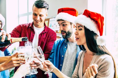 Birlikte Noel kutlayan ve gözlük şampanya dökme mutlu multiracial arkadaş Grubu