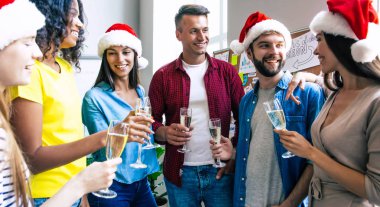 Mutlu multiracial arkadaşlar grubu şampanya bardakları ile birlikte Noel kutluyor