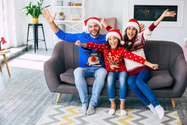 모자와 스웨터에 어머니 아버지와 가족은 소파의 크리스마스 카드를 포즈를 — 스톡 사진
