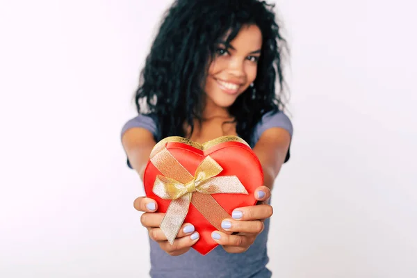 Merry mixed race woman with gift-box posing on white studio background