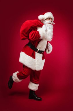  Noel ve Yeni Yıl konsepti. Çuvallı Noel Baba kostümlü bir adam portresi.