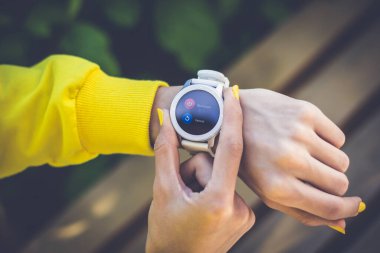 Yeniden başlat ya da kapat. Bir kızın elindeki akıllı kasetin yakın plan fotoğrafı, yeniden başlatmak ya da kapatmak istiyor, sarı tırnaklı iki kızın parmakları düğmelere basıyor..