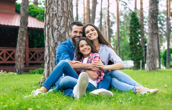 Piękna Szczęśliwa Rodzina Siedząc Razem Trawie Przytulając Się Relaksując Się — Zdjęcie stockowe