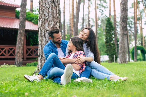 Krásná Šťastná Rodina Zatímco Sedí Spolu Trávě Objímají Relaxovat Venku — Stock fotografie
