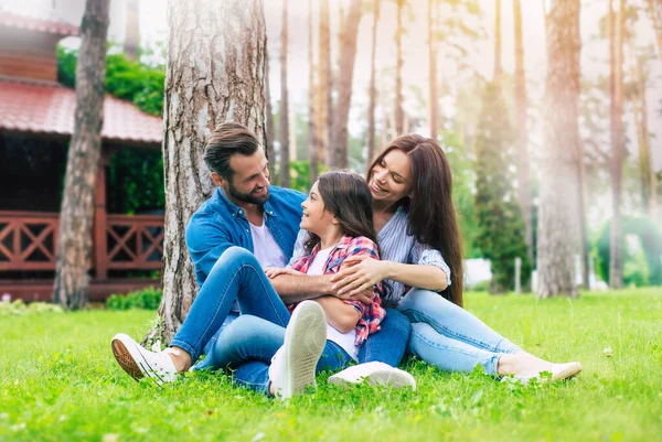 Mooi Gelukkig Gezin Terwijl Samen Zitten Het Gras Knuffelen Elkaar — Stockfoto