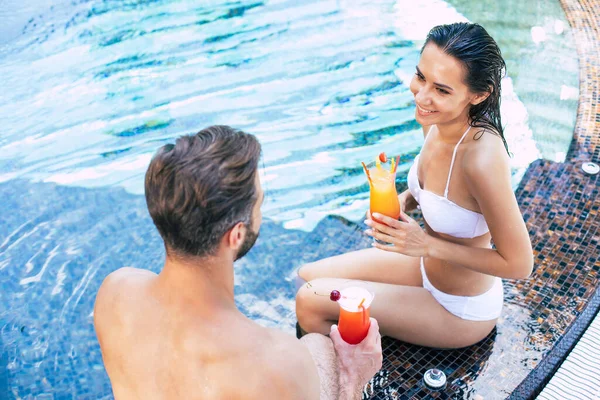 stock image Cheerful couple in love are resting in a swimming pool while summer vacation.