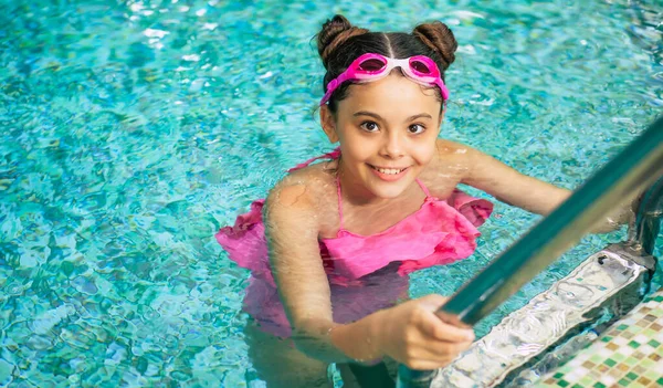 穿着护目镜和泳衣在游泳池里快乐而美丽的小女孩在度假或游泳课上玩得很开心 — 图库照片