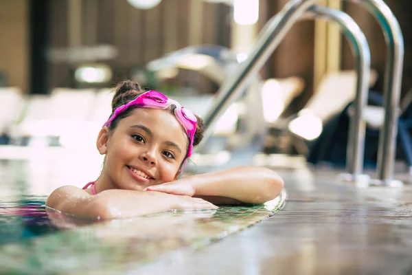 穿着护目镜和泳衣在游泳池里快乐而美丽的小女孩在度假或游泳课上玩得很开心 — 图库照片