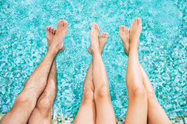 Havuzda insan bacakları. Bir yaz otelinde tatil. Bacakları su altındaydı. Aile yüzme havuzunda