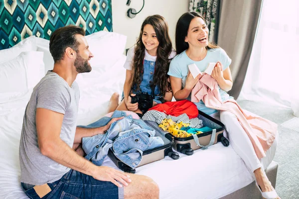 荷物や服をアンパックしながら一緒に楽しみながら 豪華なホテルの部屋で美しく若い幸せと興奮した家族 夏の休暇または旅行 — ストック写真