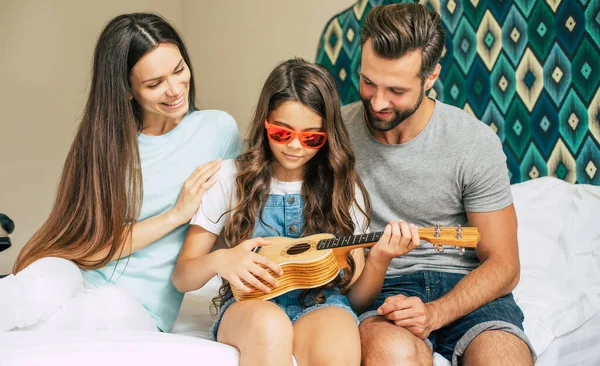 Beautiful young happy and excited family in a luxury hotel room while unpacking stuff and clothes and having fun together. Vacation or trip in summer