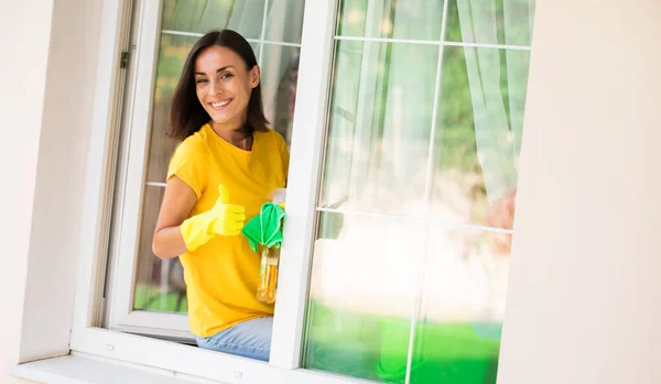 Beautiful Young Happy Woman Using Duster Spray While Cleaning Window — Stock Photo, Image