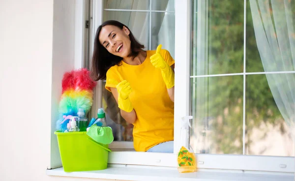 美しい若い幸せな女性は家の窓を掃除しながらダスターとスプレーを使用しています 宿題のコンセプト — ストック写真