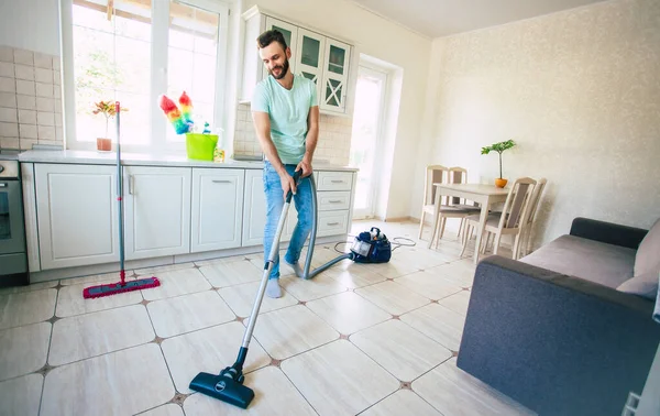 Χαρούμενος Όμορφος Νεαρός Γενειοφόρος Καθαρίζει Πάτωμα Στην Κουζίνα Και Διασκεδάζει — Φωτογραφία Αρχείου