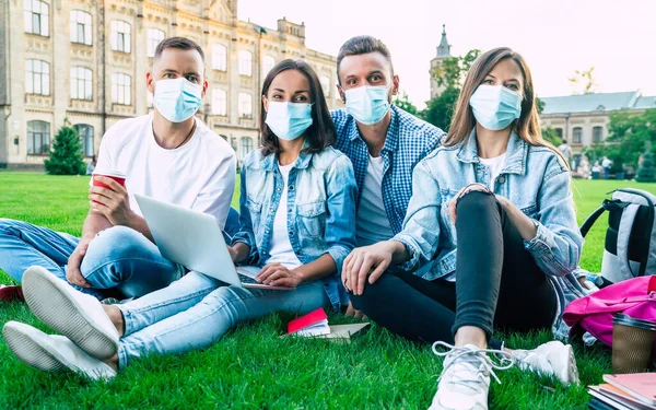Ομάδα Νεαρών Φοιτητών Ιατρικές Μάσκες Φορητό Υπολογιστή Και Βιβλία Σπουδάζουν — Φωτογραφία Αρχείου