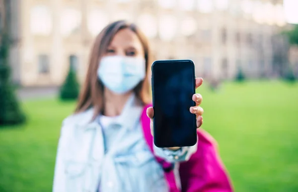 Молода Впевнена Студентка Медичній Масці Вказує Порожній Екран Смартфона Стоїть — стокове фото