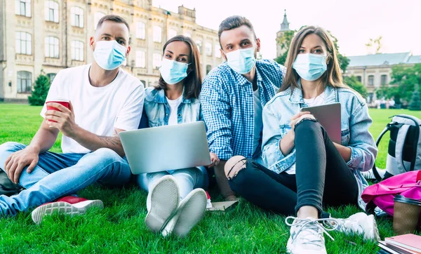 Grupo Jóvenes Estudiantes Máscaras Médicas Con Portátil Libros Están Estudiando — Foto de Stock