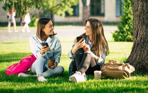 Mutlu Heyecanlı Kotlu Kız Arkadaş Üniversite Parkında Akıllı Telefonlarıyla Rahatlıyor — Stok fotoğraf
