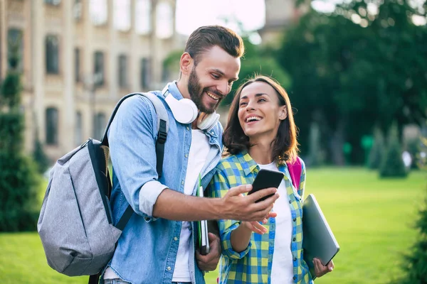 Dwoje Szczęśliwych Podekscytowanych Uczniów Plecakami Smartfonem Rozmawia Spaceruje Świeżym Powietrzu — Zdjęcie stockowe