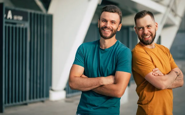 Két Vidám Barát Vagy Testvér Színes Pólóban Háttal Állnak Egymásnak — Stock Fotó