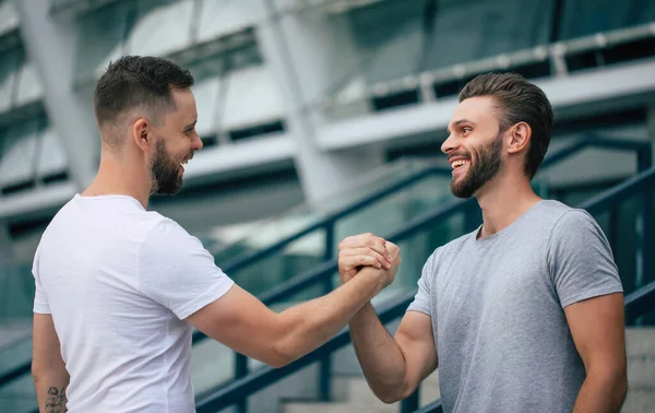 Férfibarát Kézfogás Két Fiatal Szakállas Jóképű Barát Alkalmi Pólóban Pózol — Stock Fotó