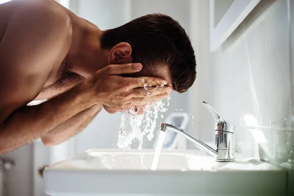 Przystojny Młody Nagi Mężczyzna Myje Twarz Łazience Domu — Zdjęcie stockowe