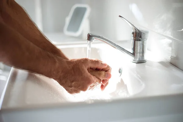 Close up photo of males hands with soap in the wash basin. Safety health procedure, pandemic, antibacterial.